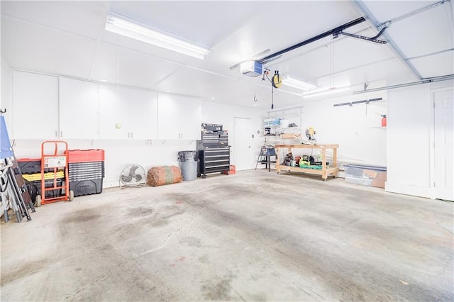 garage with a garage door opener and a workshop area