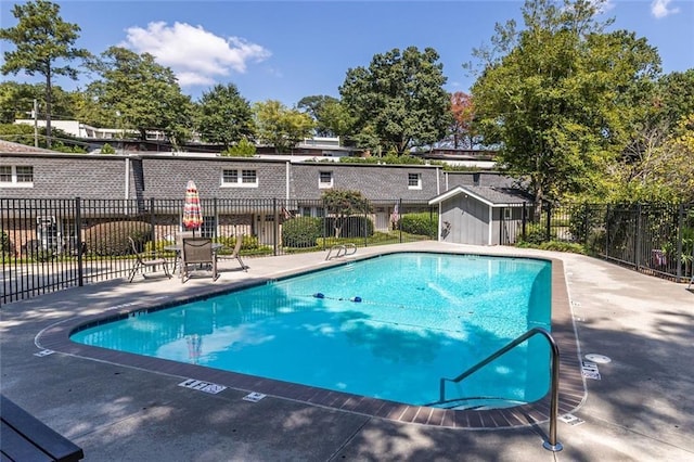 community pool with an outbuilding and fence