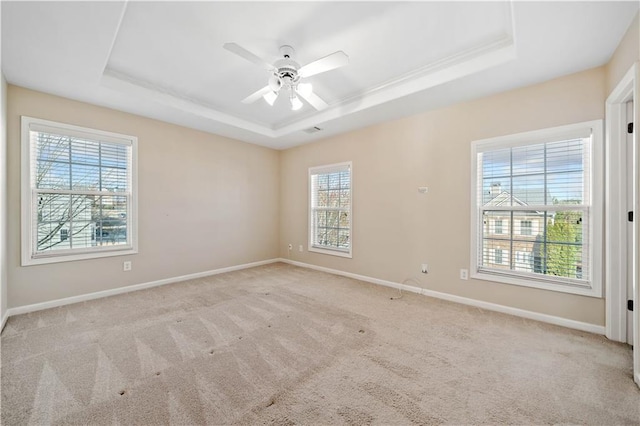 unfurnished room featuring carpet flooring, baseboards, a tray ceiling, and a ceiling fan