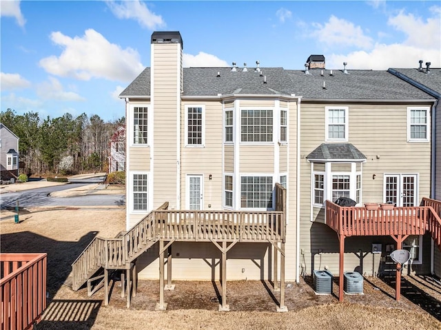 back of property with a wooden deck, central AC unit, and a chimney