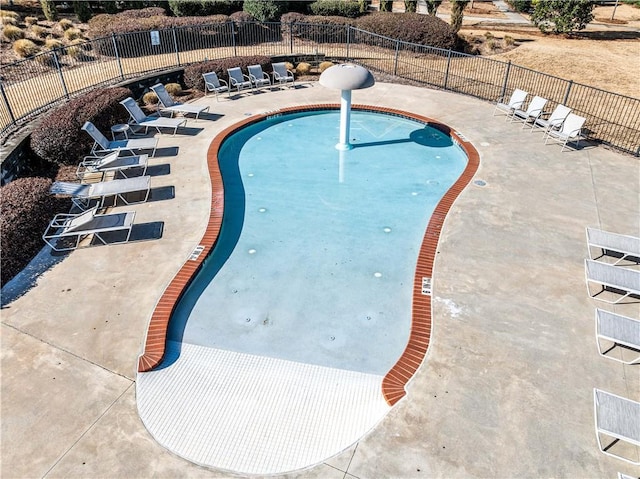 pool with a patio and fence