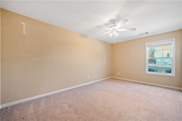 empty room with ceiling fan, baseboards, visible vents, and light carpet