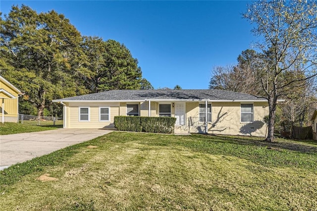 ranch-style house featuring a front yard and fence