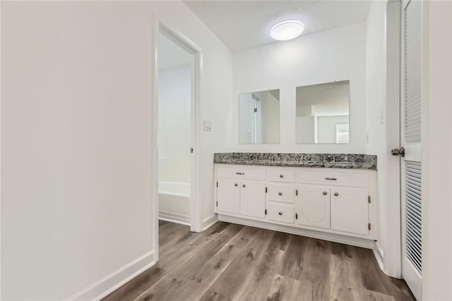 bathroom with wood finished floors, vanity, and baseboards