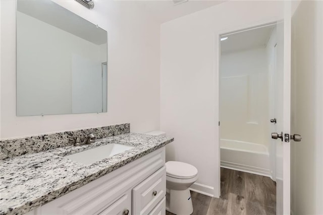 bathroom featuring vanity, shower / bathing tub combination, wood finished floors, and toilet