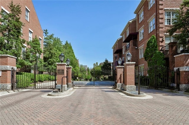 view of street with street lighting, a gate, a gated entry, and curbs