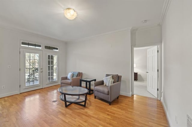 living area featuring ornamental molding, visible vents, light wood-style flooring, and baseboards