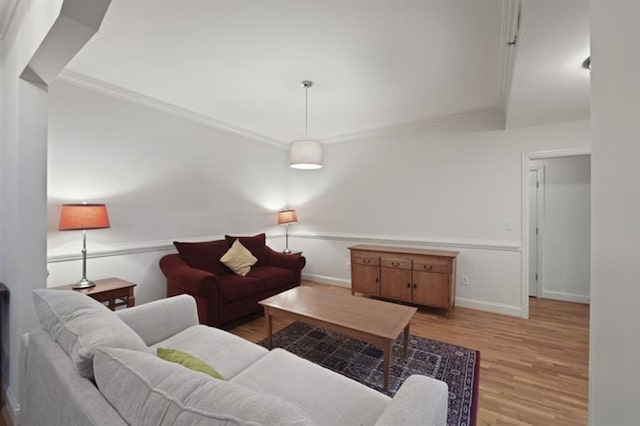 living room with crown molding, baseboards, and wood finished floors