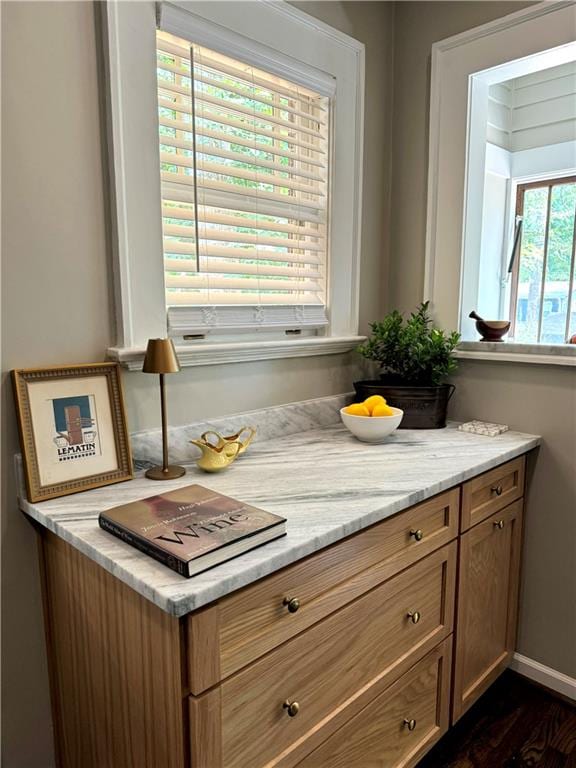 bar featuring dark wood-type flooring and light stone countertops