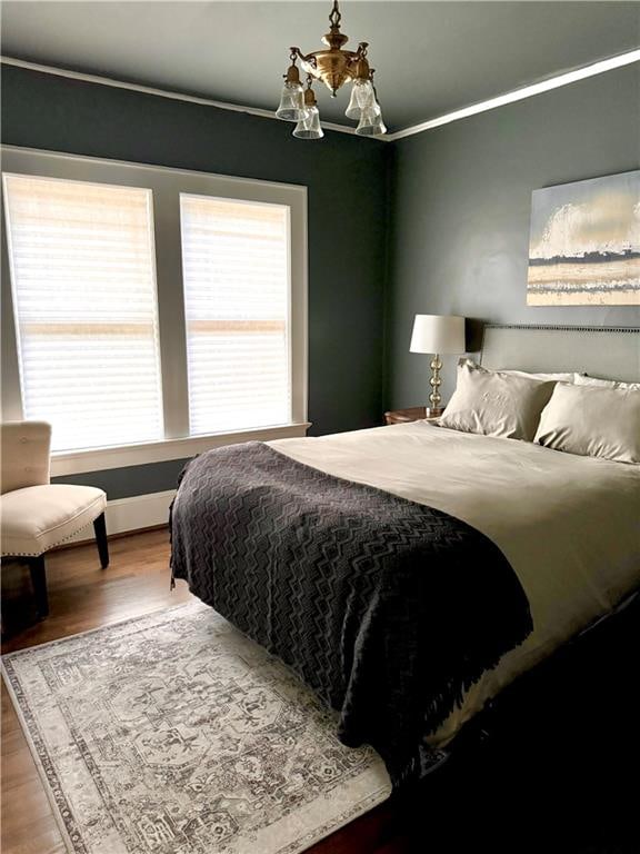 bedroom featuring ornamental molding and hardwood / wood-style flooring