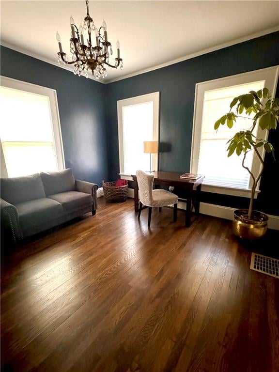 living room featuring crown molding, a healthy amount of sunlight, a chandelier, and dark wood-type flooring