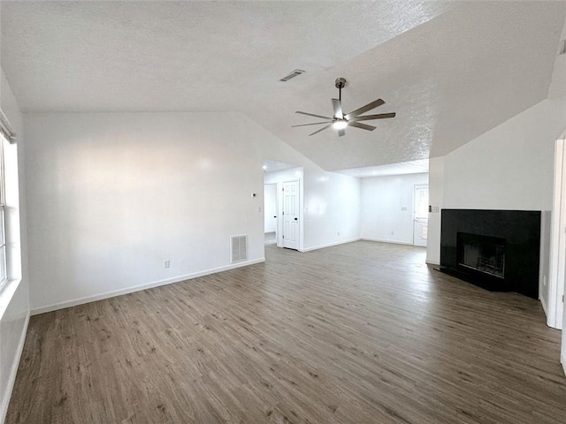 unfurnished living room with wood finished floors, a ceiling fan, visible vents, and lofted ceiling