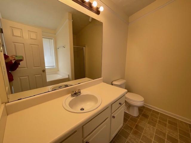 full bathroom featuring toilet, vanity, and shower with separate bathtub