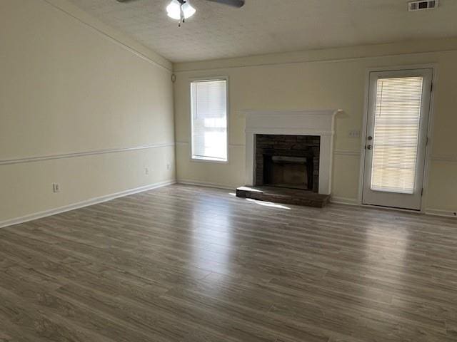 unfurnished living room featuring dark hardwood / wood-style flooring, ceiling fan, and a fireplace