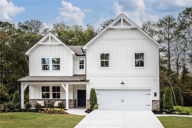 modern farmhouse style home with a garage, concrete driveway, a porch, board and batten siding, and brick siding