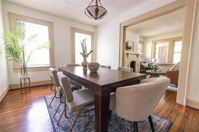 dining area with a healthy amount of sunlight, hardwood / wood-style flooring, and a textured ceiling