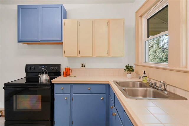 kitchen with blue cabinetry, light countertops, black electric range oven, a sink, and baseboards