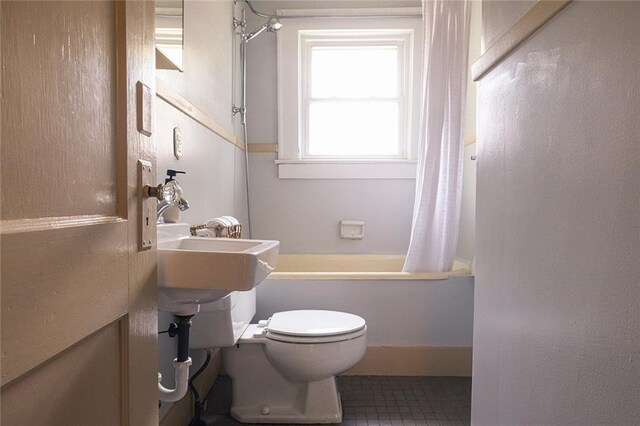 bathroom with a sink, toilet, and shower / bathtub combination with curtain