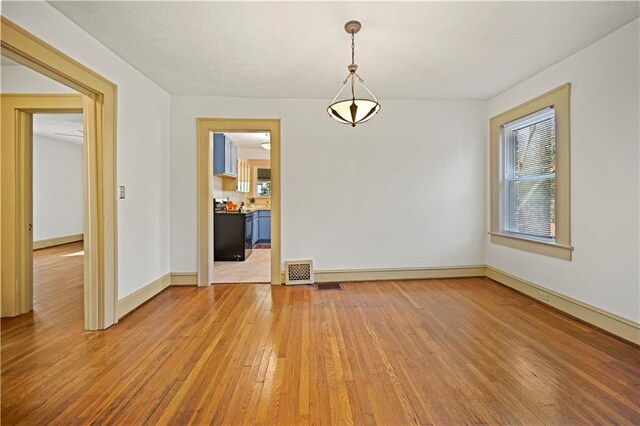 unfurnished living room with wood-type flooring, a fireplace, a textured ceiling, and baseboards