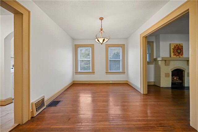 unfurnished dining area featuring visible vents, baseboards, and wood finished floors