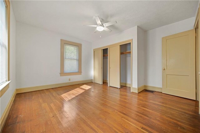 empty room featuring visible vents, a textured ceiling, baseboards, and wood finished floors