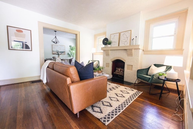 living room with dark wood-style floors, a fireplace, and baseboards