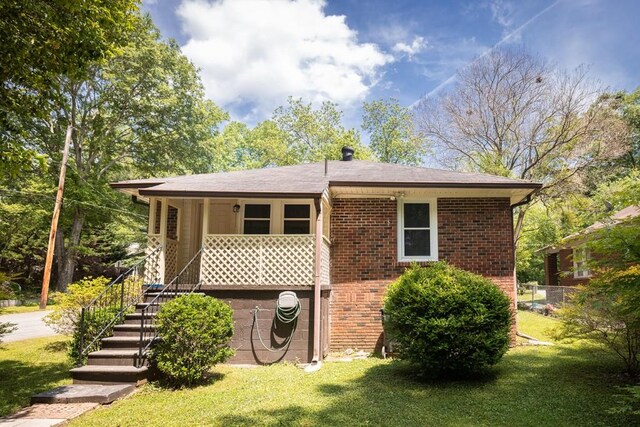 view of front of home with brick siding, stairway, and a front lawn