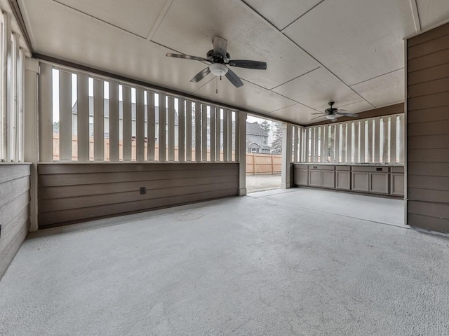 unfurnished sunroom with ceiling fan