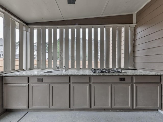 details with sink, wood walls, and stainless steel gas cooktop