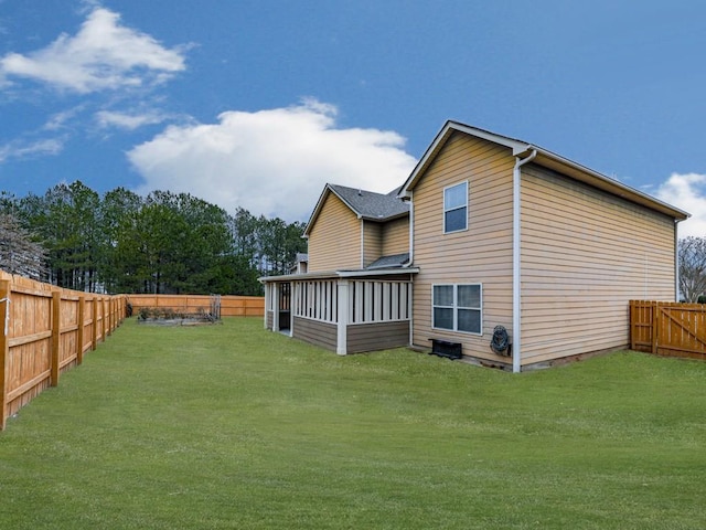 back of house with a yard and a sunroom