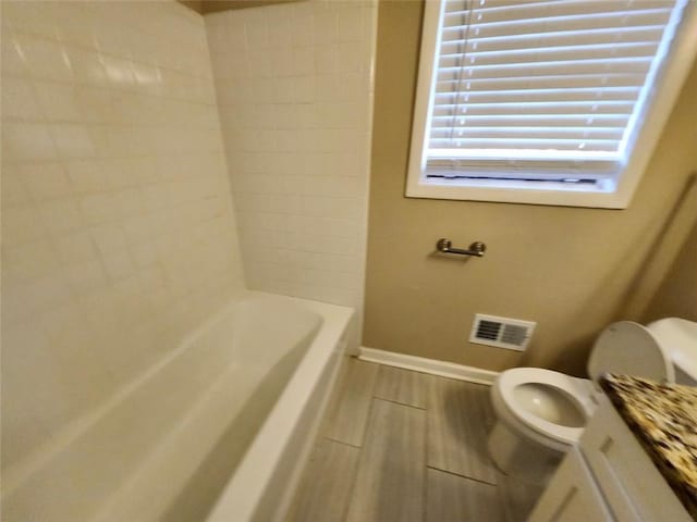 full bathroom featuring toilet, bathing tub / shower combination, and vanity