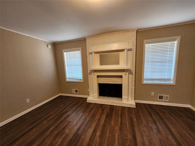 unfurnished living room with a brick fireplace, ornamental molding, and dark hardwood / wood-style floors