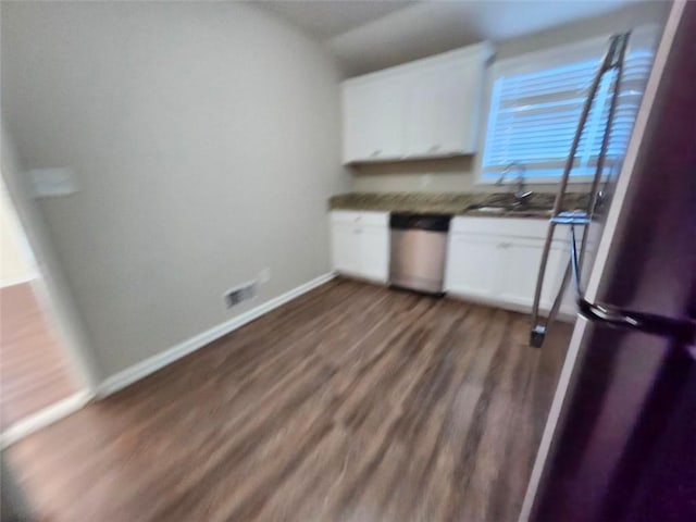 kitchen featuring white cabinets, dark hardwood / wood-style floors, vaulted ceiling, and appliances with stainless steel finishes