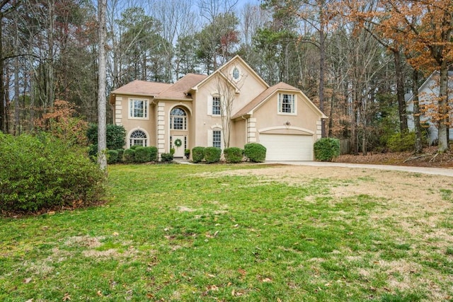 view of front of house with a front lawn, concrete driveway, and stucco siding