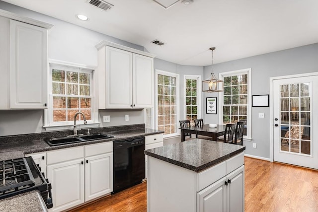 kitchen featuring visible vents, light wood-style flooring, black appliances, white cabinetry, and a sink