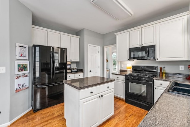 kitchen with black appliances, white cabinetry, and light wood finished floors