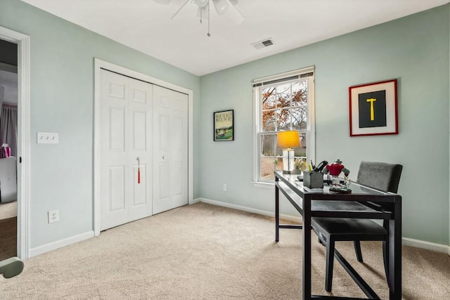 carpeted home office with a ceiling fan, visible vents, and baseboards