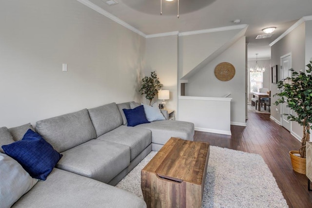 living room with dark wood-type flooring, a chandelier, and crown molding