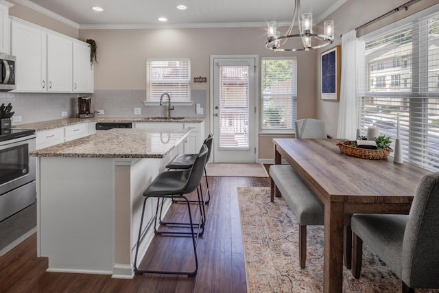 kitchen with hanging light fixtures, white cabinets, tasteful backsplash, and dark hardwood / wood-style floors