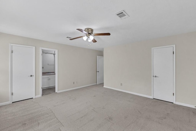 unfurnished bedroom featuring ceiling fan, visible vents, carpet floors, baseboards, and connected bathroom