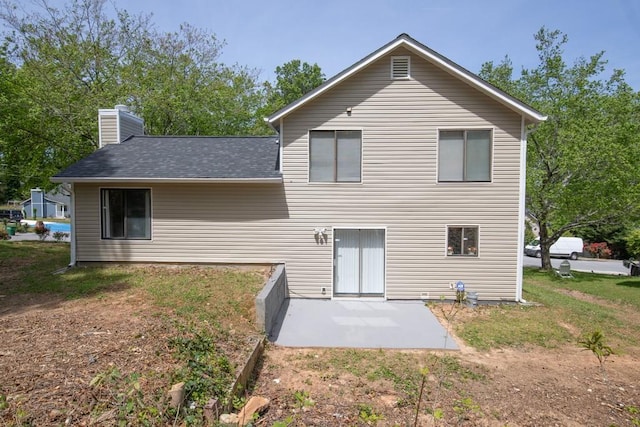 rear view of house with a chimney and a patio area