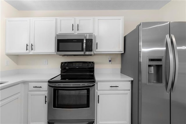 kitchen featuring light countertops, appliances with stainless steel finishes, and white cabinetry