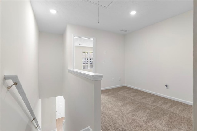 spare room with attic access, light colored carpet, baseboards, visible vents, and recessed lighting