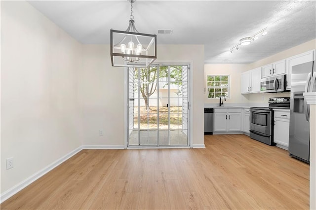 kitchen featuring light wood-style flooring, baseboards, visible vents, an inviting chandelier, and appliances with stainless steel finishes