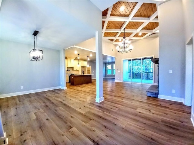 136 Rainey Rd, Temple, GA 30179 - unfurnished living room featuring a chandelier, a high ceiling, wood finished floors, and a wooden ceiling with exposed beams