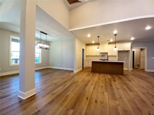 136 Rainey Rd, Temple, GA 30179 - kitchen featuring dark wood-type flooring, open floor plan, white cabinetry, an island with sink, and pendant lighting