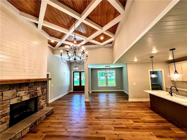 136 Rainey Rd, Temple, GA 30179 - unfurnished living room with a chandelier, coffered ceiling, a stone fireplace, a wood ceiling with exposed beams, and dark wood-type flooring