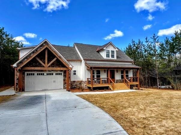 view of front facade with board and batten siding, concrete driveway, a garage, and covered porch