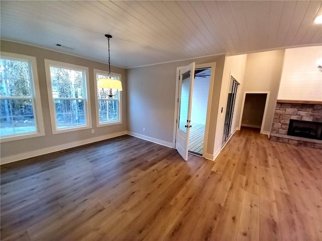 136 Rainey Rd, Temple, GA 30179 - unfurnished dining area with a chandelier, hardwood / wood-style flooring, a stone fireplace, and wood ceiling