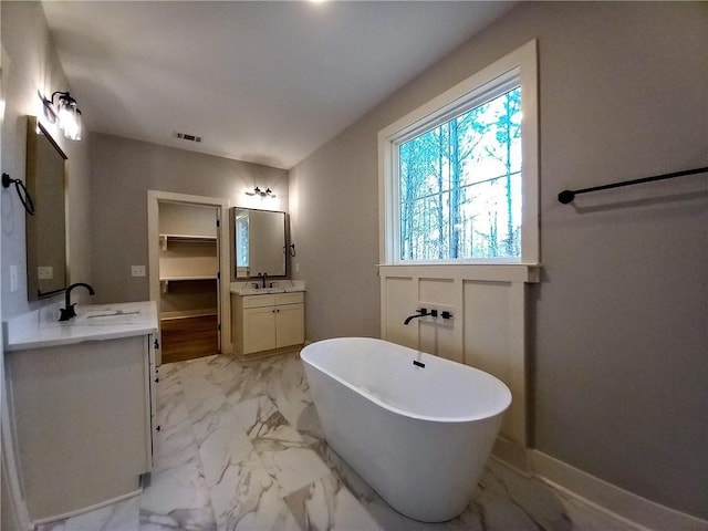 136 Rainey Rd, Temple, GA 30179 - full bathroom with marble look tile flooring, a soaking tub, and two vanities